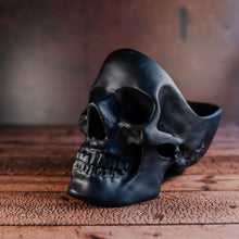 Load image into Gallery viewer, black skull tidy facing to the left displayed on a wooden table