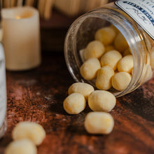 Load image into Gallery viewer, Lemon bon bons spilling out a plastic tub by a candle