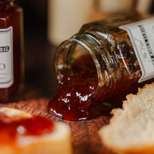 Load image into Gallery viewer, Strawberry jam spilling onto a table