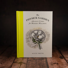 Load image into Gallery viewer, The Physick Garden by Alice Smith book displayed on a wooden slatted table