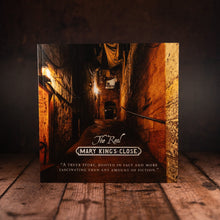 Load image into Gallery viewer, The Real Mary King's Close AR Guidebook front cover displayed against a wooden slatted background