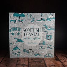 Load image into Gallery viewer, The Scottish Coastal Colouring Book displayed on a wood panelled desk