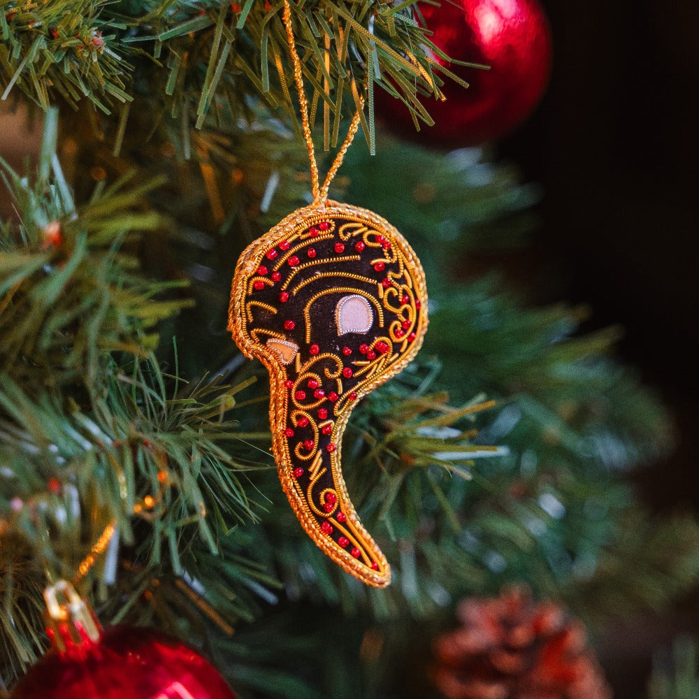 Hand-stitched Venetian plague doctor mask displayed on a Christmas tree 
