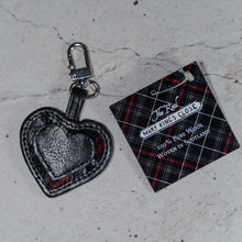 Load image into Gallery viewer, The Real Mary King&#39;s Close black leather heart keyring with a label displaying a 100% Pure Wool Woven in Scotland message

