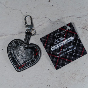 The Real Mary King's Close black leather heart keyring with a label displaying a 100% Pure Wool Woven in Scotland message