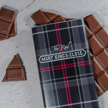 Load image into Gallery viewer, The Real Mary King&#39;s Close branded tartan chocolate bar, with opened chocolate pieces scattered around
