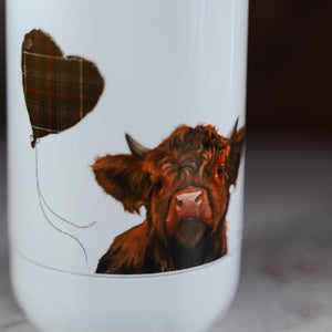 Close up of bottom of water bottle with highland cow painting and tartan balloon