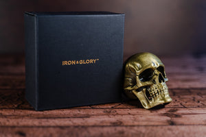 Gold skull bottle opener beside an Iron & Glory branded black box