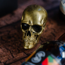 Load image into Gallery viewer, small gold skull bottle opener from above
