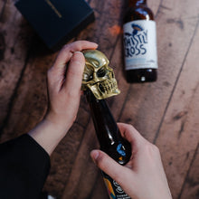 Load image into Gallery viewer, Gold skull bottle opener being used to open a beer
