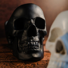 Load image into Gallery viewer, Black skull tidy facing forwards and displayed on a wooden table
