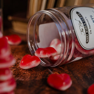 Jelly heart sweets spilling onto a table out of a plastic tub