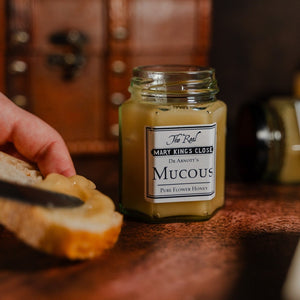 Pure flower honey being spread on crusty bread from a jar of "Mucous" at The Real Mary King's Close