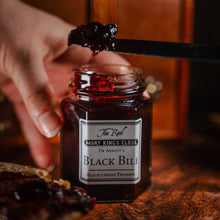 Load image into Gallery viewer, Blackcurrant preserve being scooped out of a jar labelled &quot;black bile&quot;
