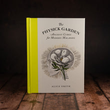 Load image into Gallery viewer, The Physick Garden by Alice Smith book displayed on a wooden slatted table
