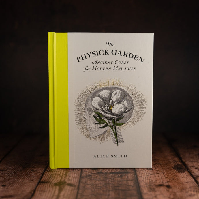 The Physick Garden by Alice Smith book displayed on a wooden slatted table