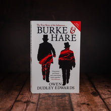 Load image into Gallery viewer, Front cover of Burke &amp; Hare by Owen Dudley Edwards, displayed on a wooden slatted desk
