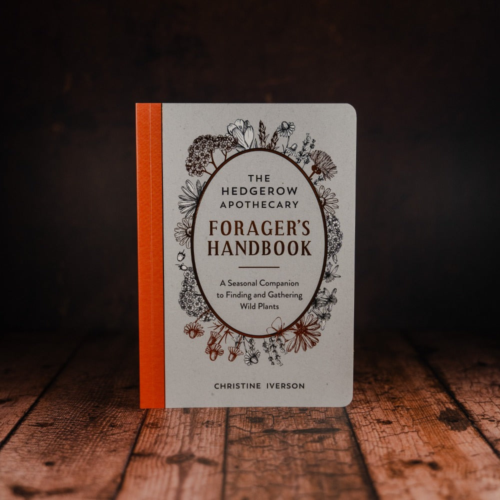 forager's handbook stood upright on wooden table 