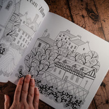 Load image into Gallery viewer, Line drawing of Edinburgh&#39;s Dean Village for colouring in as displayed in an open book
