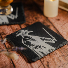 Load image into Gallery viewer, Flat image of a slate coaster displaying a charcoal image of a full-length plague doctor costume
